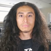 Young man with long dark curly hair